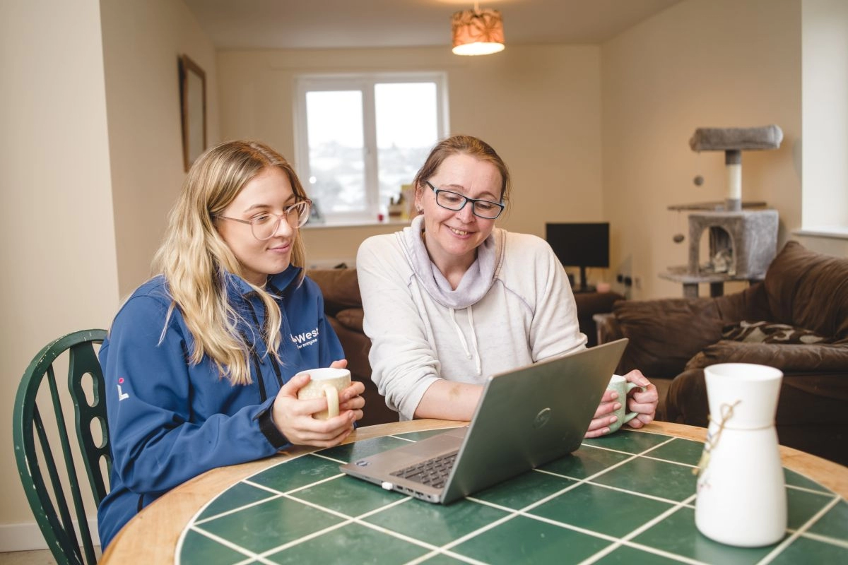 Two women looking a laptop checking their account