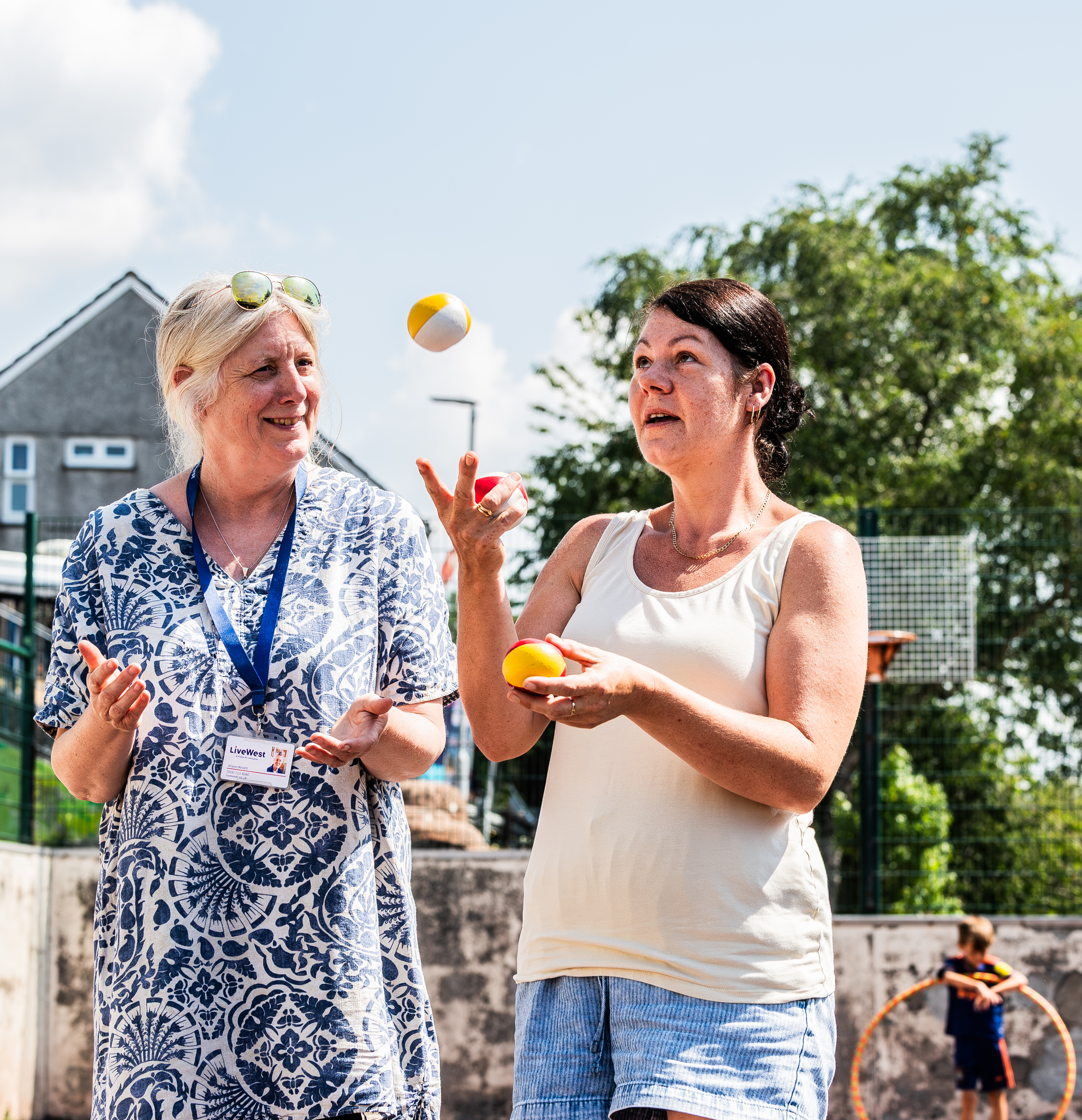 A LiveWest colleague and customer are juggling and smiling at a community event