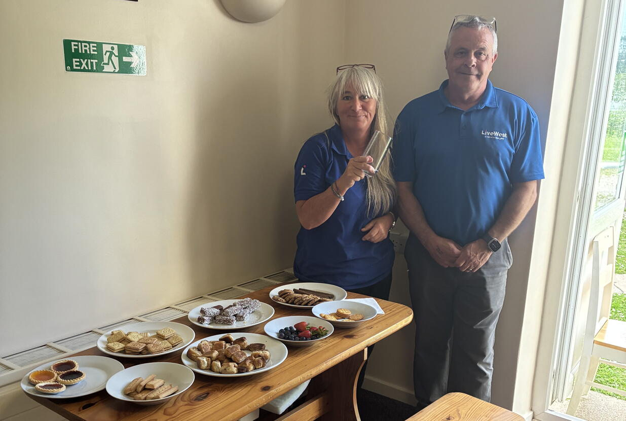 LiveWest colleagues smiling next to a table of food