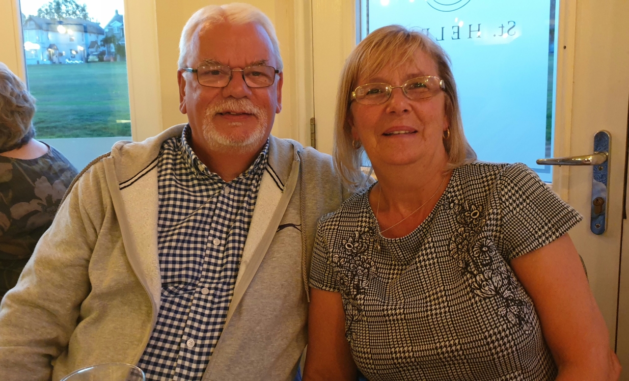 Larry (left) smiling alongside his wife.