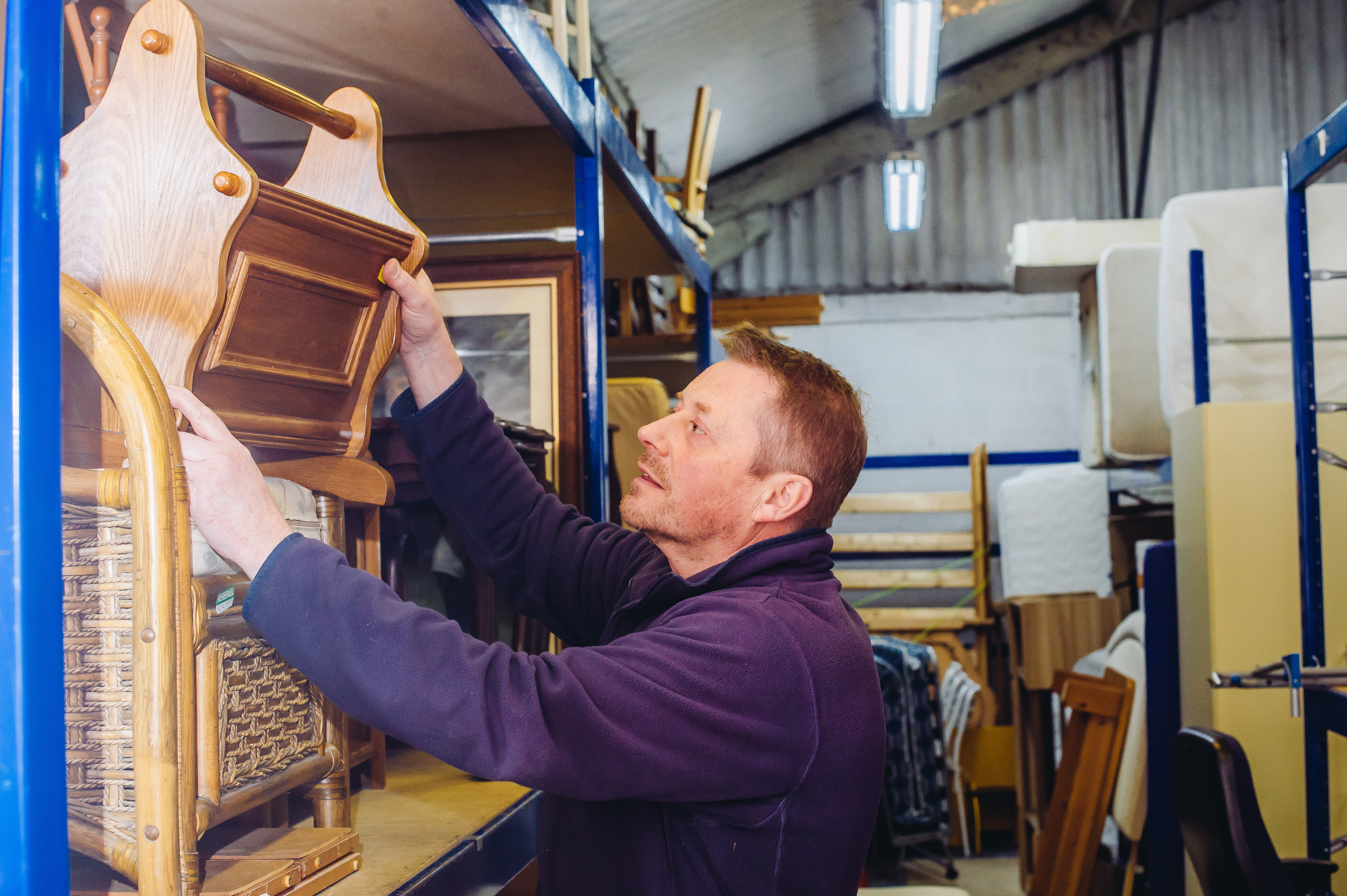 Man lifting a table from a shelf