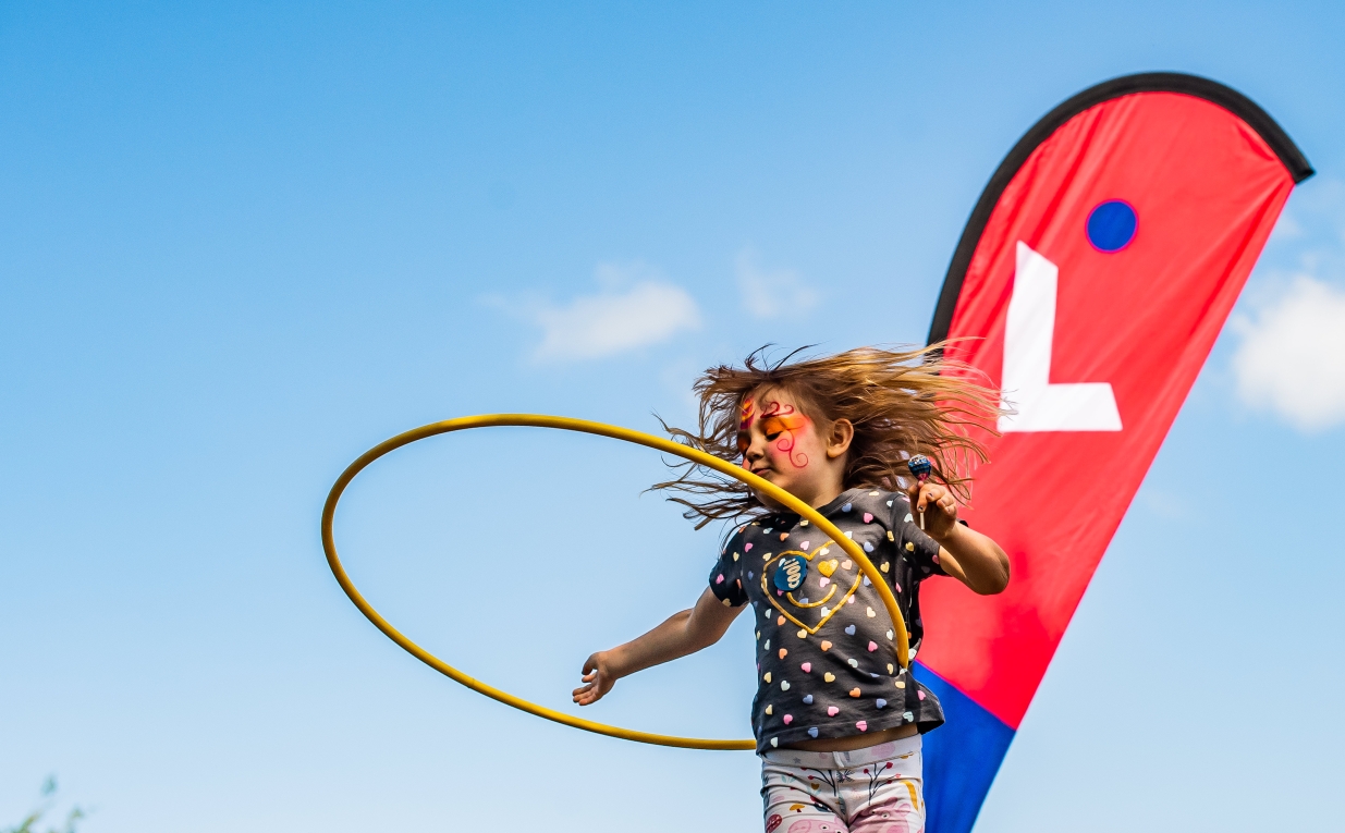 Young girl playing with a hula hoop at a LiveWest community event