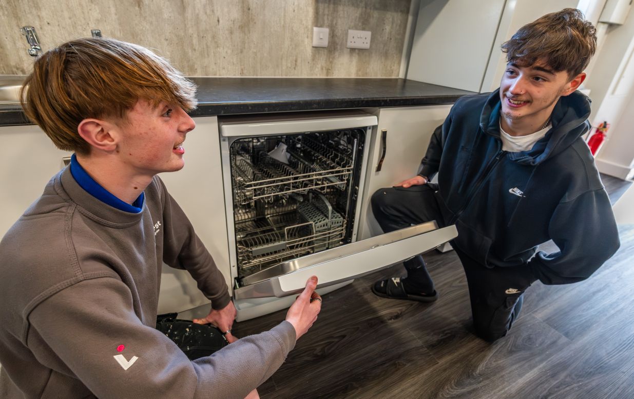 A LiveWest apprentice showing the new dishwasher.