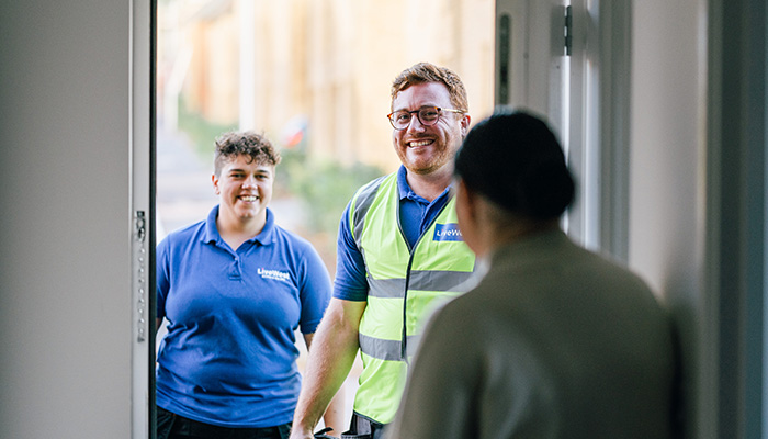 LiveWest colleagues being greeted by a customer at their front door. 