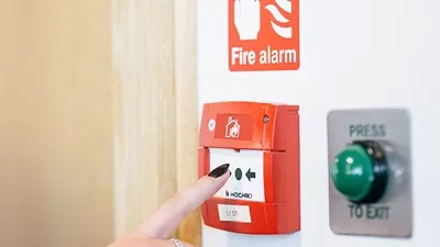 Someone pressing a fire alarm. 