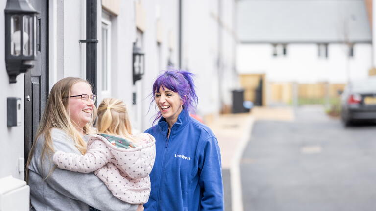 Image of a LiveWest colleague laughing with a customer and her daughter outside their home