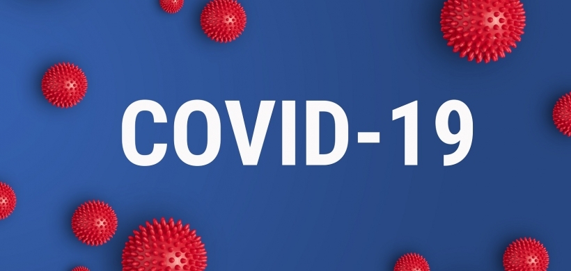 Covid-19 in white lettering on a blue background with red virus particles