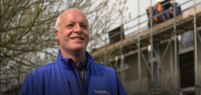 Tim Wotton in front of houses which are having solar panels installed