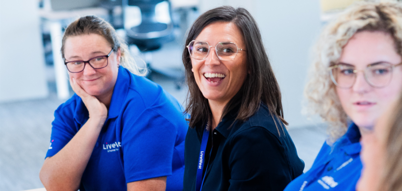 Emma Jones (middle) smiling alongside her colleagues. 