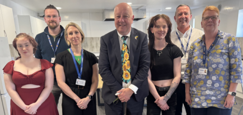 MP Steve Darling smiling with young people who live at Torbay and LiveWest colleagues.