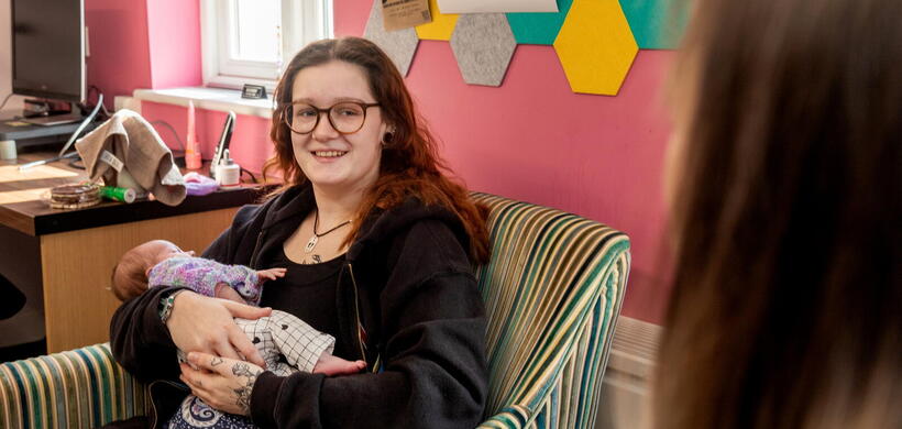 Ava talking to a LiveWest colleague whilst holding her daughter.