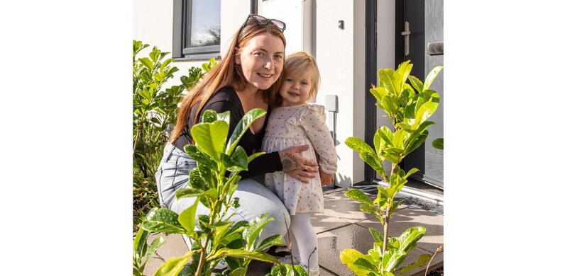 Danielle and her daughter in front of their home.