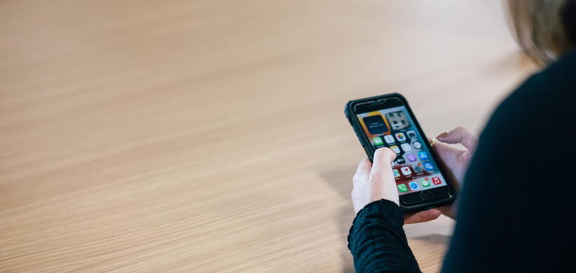 Image shows a person using a mobile phone.