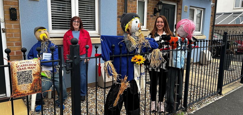 Two people stood with the scarecrows they had made.