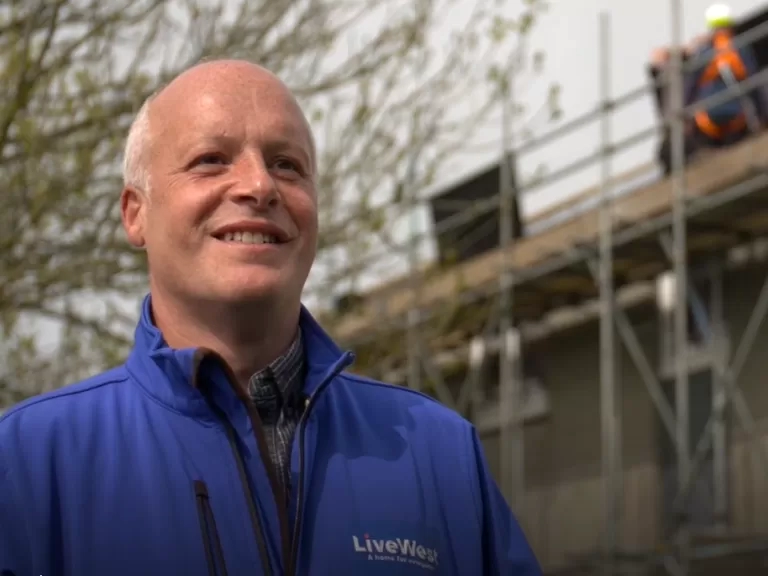 Tim Wotton in front of houses which are having solar panels installed