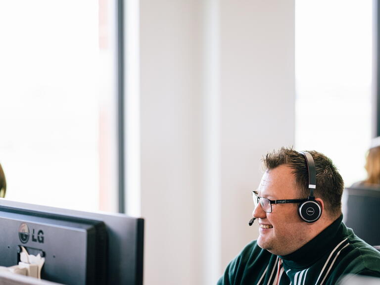 LiveWest colleague talking to a customer using a headset.