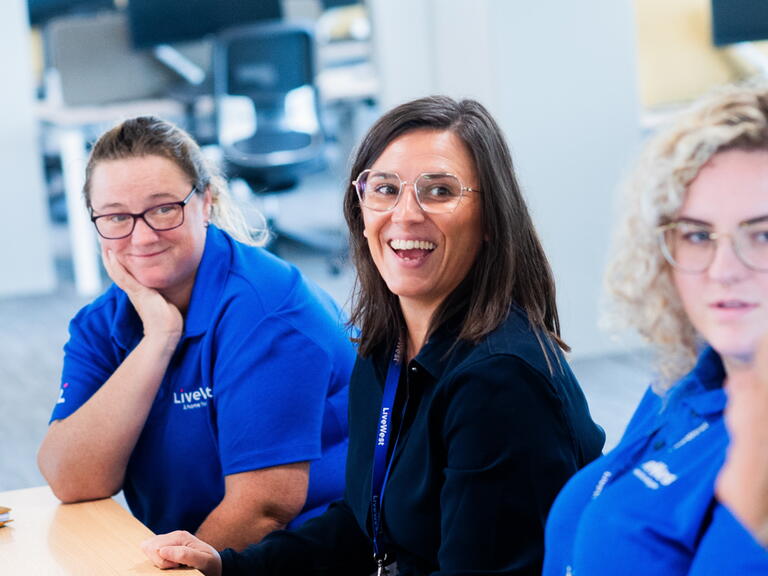 Emma Jones (middle) smiling alongside her colleagues. 