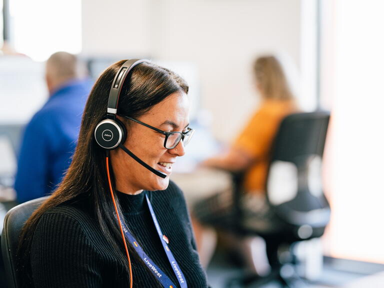 LiveWest colleague speaking on the phone using a headset.