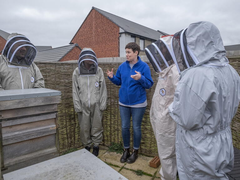 The group of volunteers at Ladden Garden Village by the beehive.