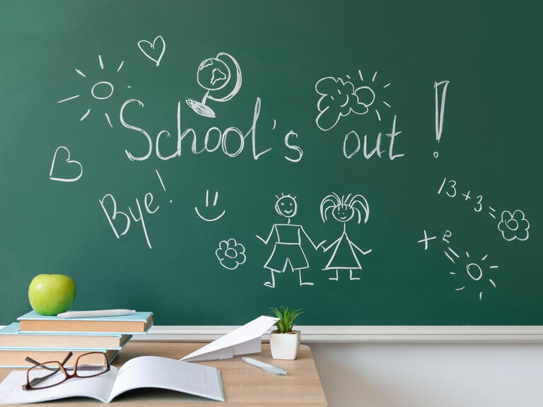 School chalk board with 'school's out' written on