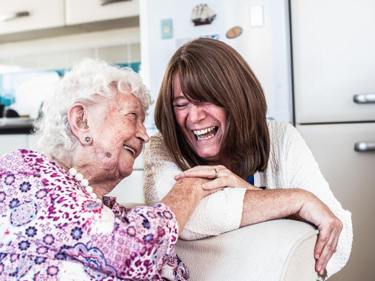 Delcie (left) smiling alongside one of our supported housing colleagues.