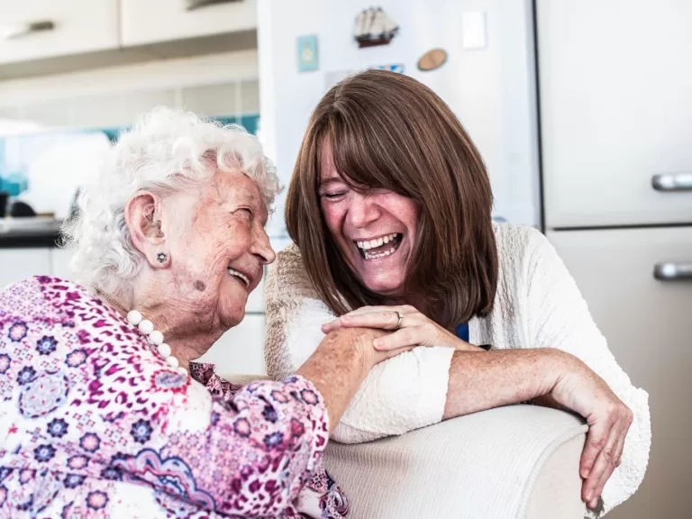 Delcie (left) smiling alongside one of our supported housing colleagues.