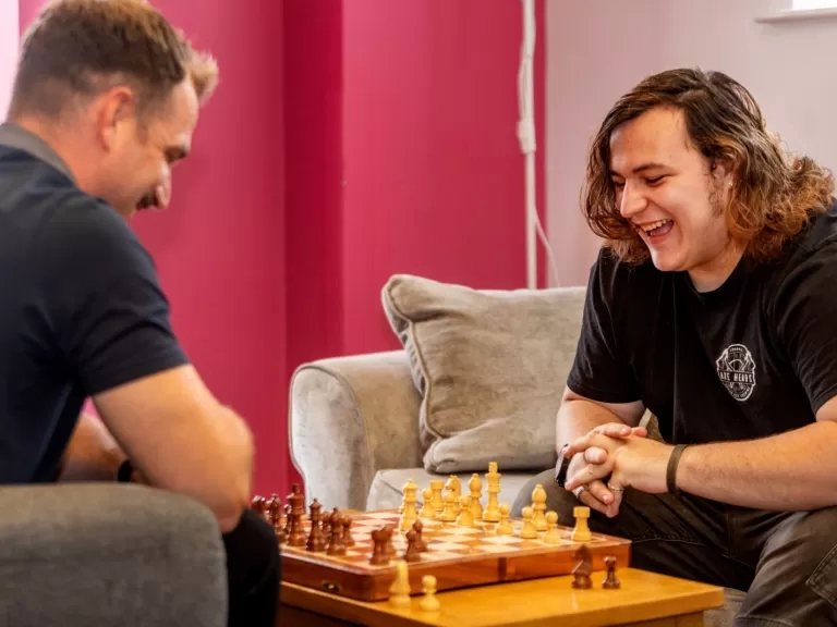 Braedon right happily playing chess with one of our support workers at the scheme.