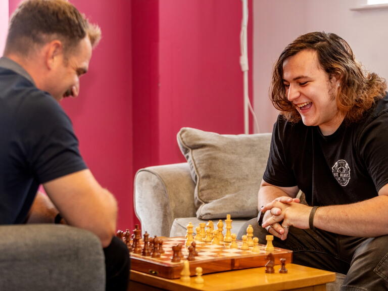 Braedon right happily playing chess with one of our support workers at the scheme.