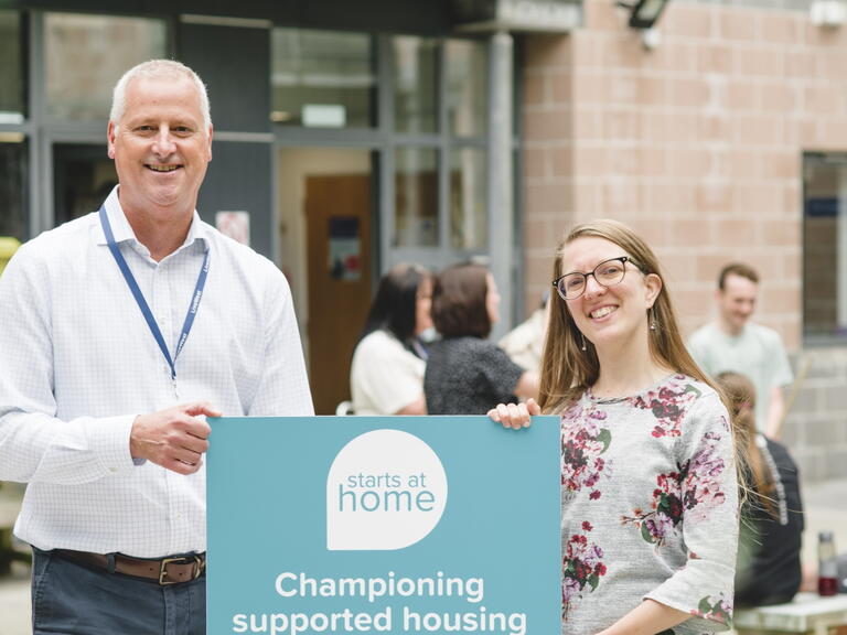 James Reseigh, LiveWest's Director of Neighbourhoods, and Suzannah Young, National Housing Federation's Policy Leader, smiling with a Starts at Home Day sign.