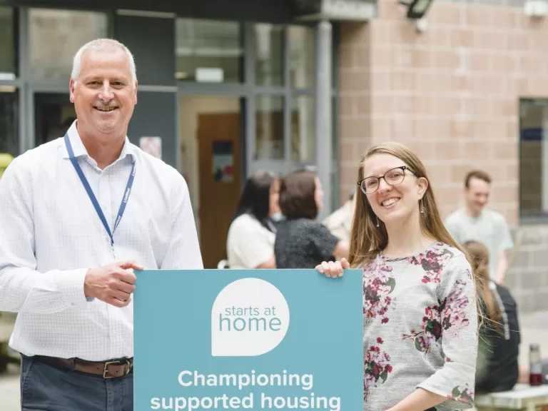 James Reseigh, LiveWest's Director of Neighbourhoods, and Suzannah Young, National Housing Federation's Policy Leader, smiling with a Starts at Home Day sign.