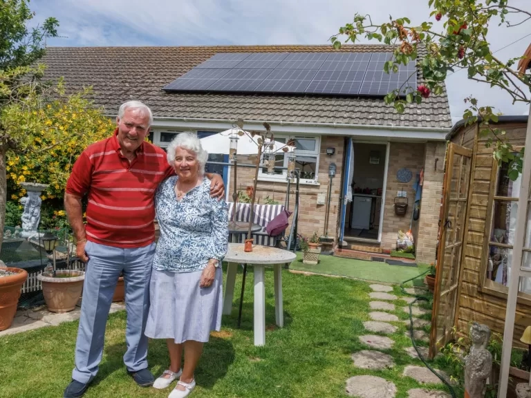 Our customers, James and Catherine, stood in their garden outside their bungalow.