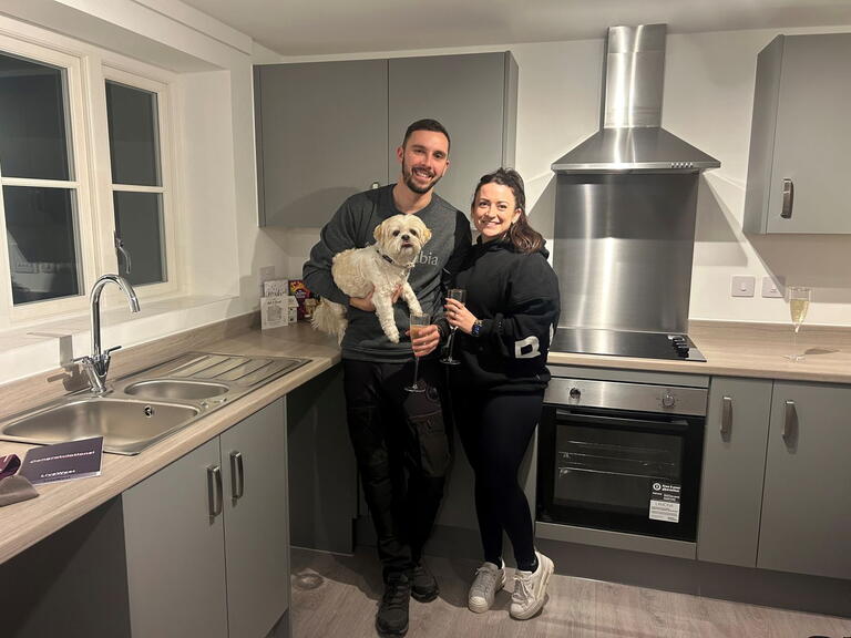 Sarah and Ashley with their dog inside their new kitchen.