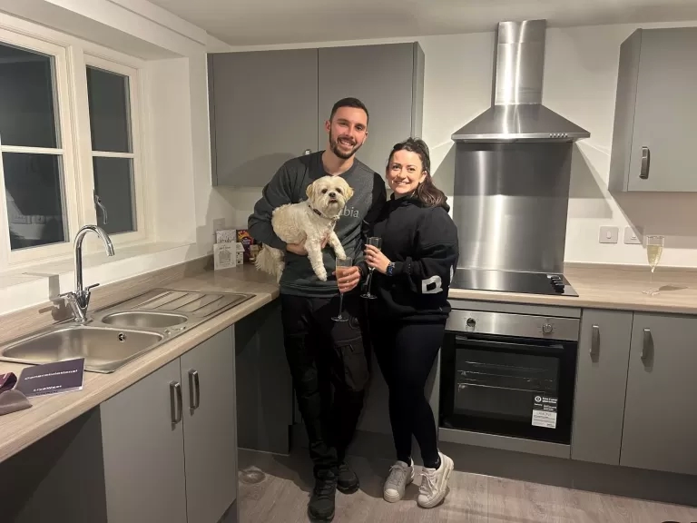 Sarah and Ashley with their dog inside their new kitchen.