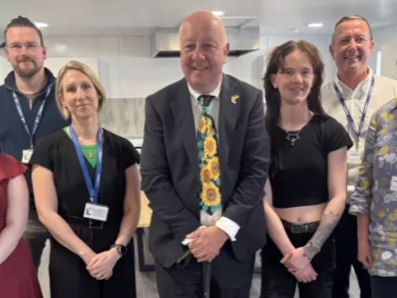 MP Steve Darling smiling with young people who live at Torbay and LiveWest colleagues.