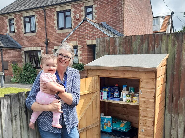 A colleague and baby stood in front of the new pantry. Image: LiveWest
