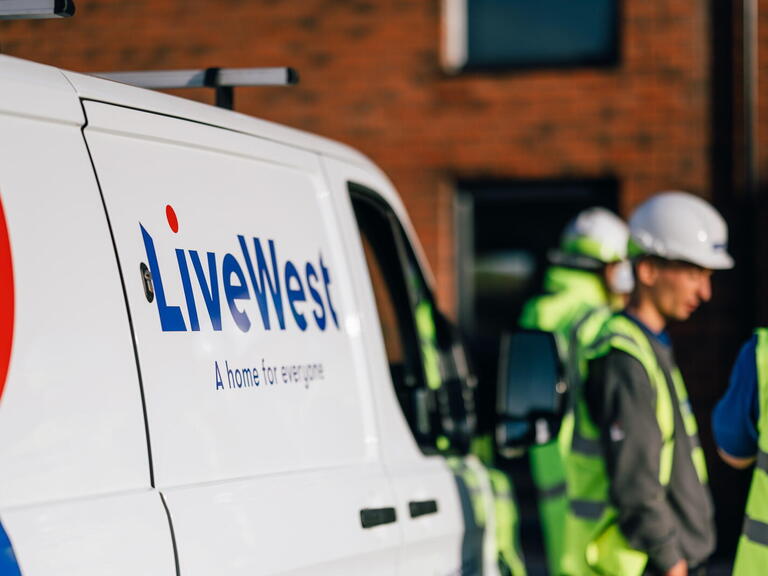 Image of a LiveWest van with colleagues wearing protective equipment next to it.