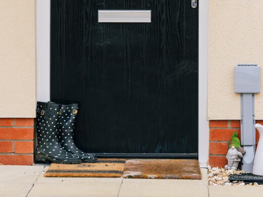 Image shows a front door with a pair of wellies and easter decorations.