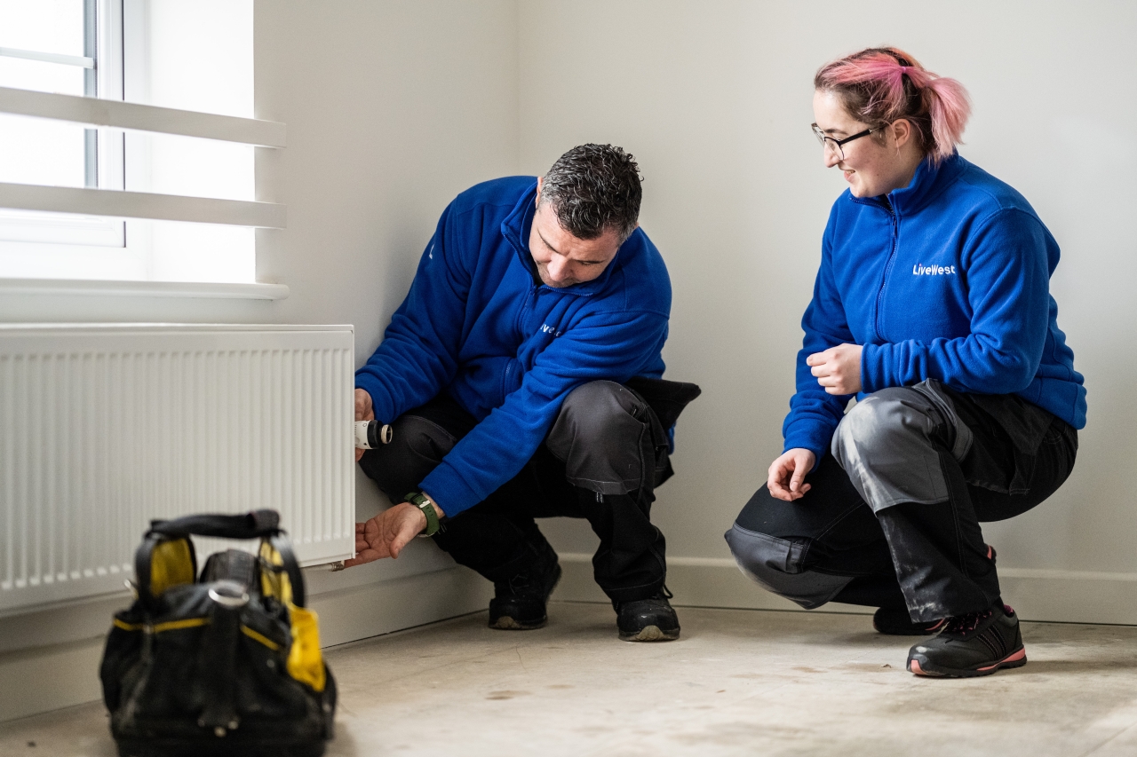 LiveWest colleagues fixing a radiator.