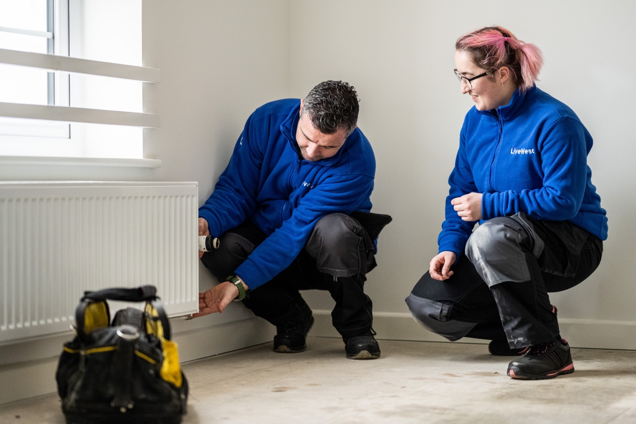 LiveWest colleagues fixing a radiator. 