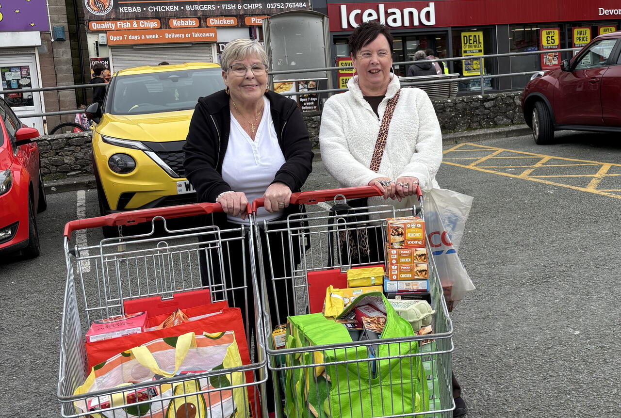 Image of two women smiling with trollies of food for the Help a Neighbour project