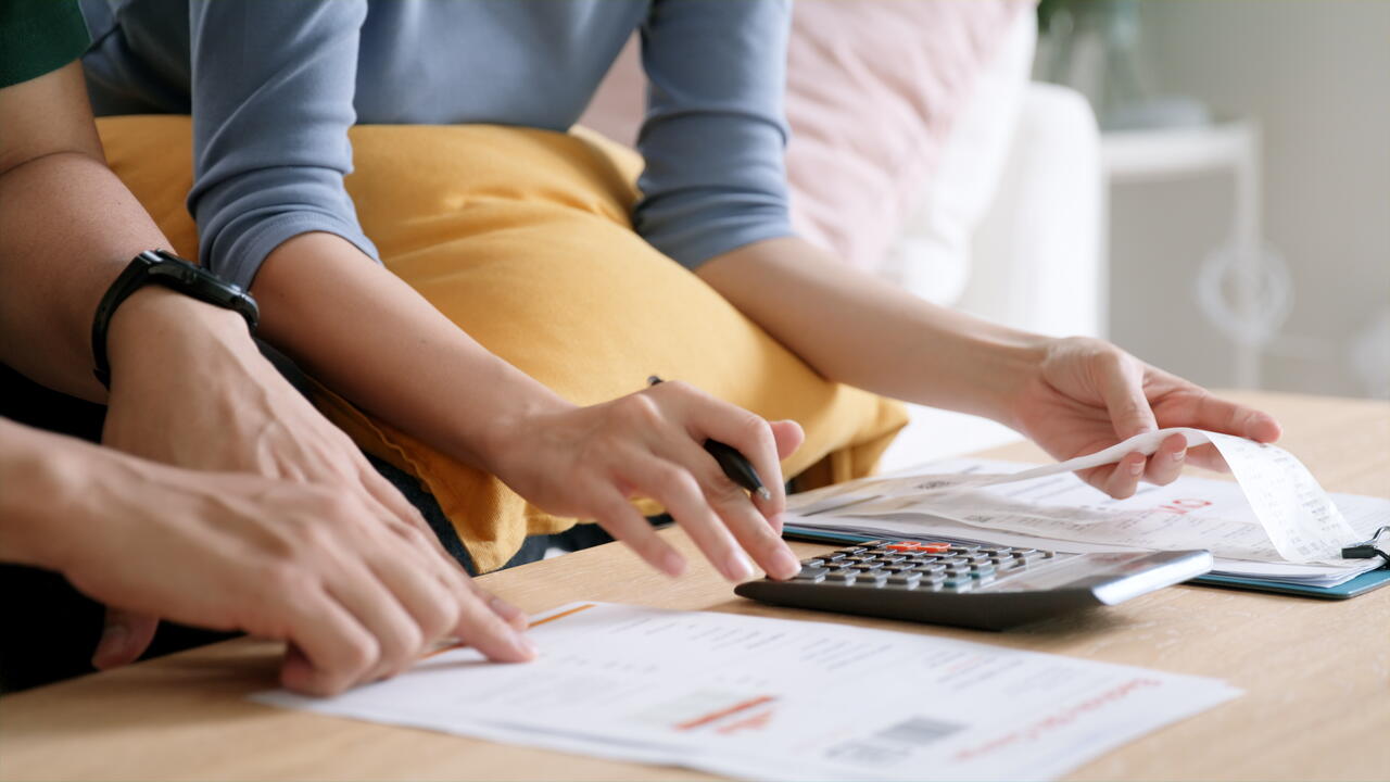 Image shows people using a calculator and a spreadsheet, supposedly figuring out energy costs.