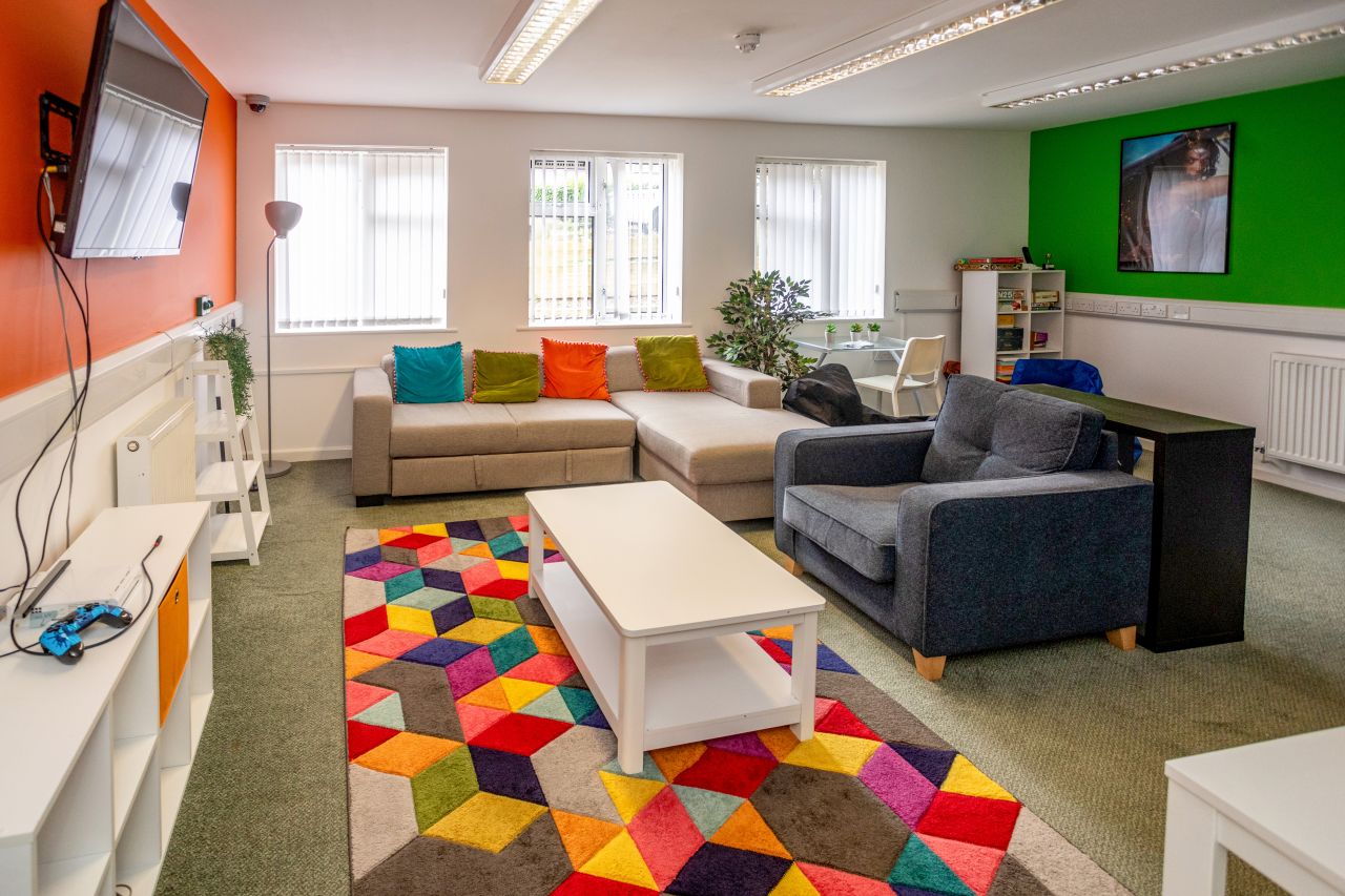 Image of a shared living space with sofas, TV and a table. 