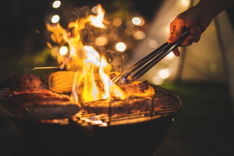Someone cooking food on a barbecue.