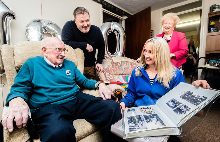 Image shows four people celebrating a 100th birthday.