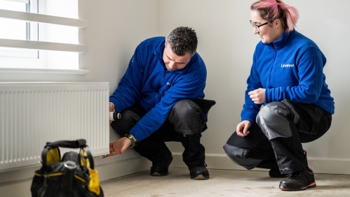 LiveWest colleagues working on a radiator. 