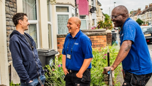 LiveWest colleagues smiling and talking with customer outside house.