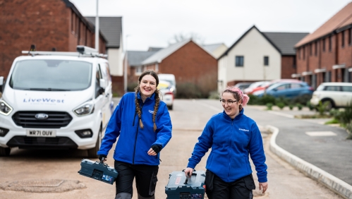 LiveWest colleagues walking along a road with toolboxes. 