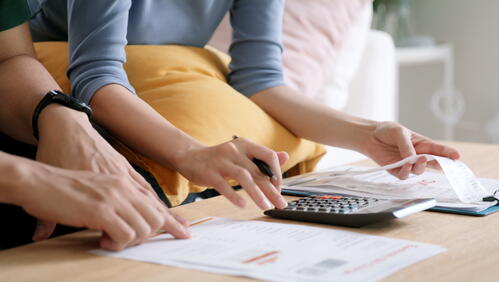 Image shows people using a calculator and a spreadsheet, supposedly figuring out energy costs.