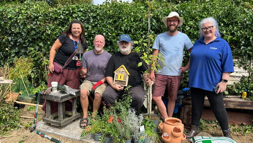 LiveWest colleagues and customers stood smiling in the communal garden